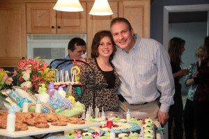 The expecting parents are as sweet as the baby-themed dessert table.